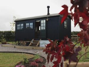 a black tiny house in a garden at The Winford Retreat in Winford