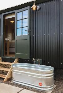 eine Badewanne vor einem Haus in der Unterkunft The Winford Retreat in Winford