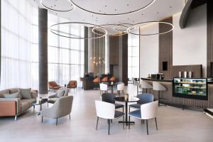 a lobby with chairs and tables and a chandelier at Courtyard by Marriott World Trade Centre, Dubai in Dubai