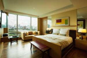 a hotel room with a bed and a couch and windows at Marriott Executive Apartment Seoul in Seoul