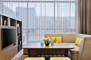 a living room with a couch and a table and a tv at Courtyard by Marriott Dubai, Al Barsha in Dubai