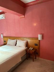 Schlafzimmer mit einem Bett und einem Tisch mit einem Telefon in der Unterkunft Hotel Majorelle in Marrakesch