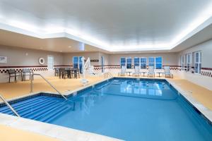 a large swimming pool in a large room with tables and chairs at Residence Inn New Bedford Dartmouth in North Dartmouth