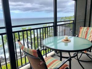 d'une table et de chaises sur un balcon avec vue sur l'océan. dans l'établissement AMAZING OCEAN VIEW - Kona Alii Condo KA606, à Kailua-Kona