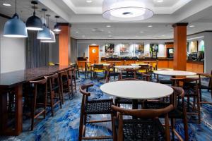 a restaurant with tables and chairs and a bar at Fairfield Inn and Suites by Marriott Gadsden in Gadsden