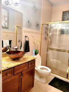 a bathroom with a sink and a toilet and a shower at Cape Paradise B & B in Cape Coral
