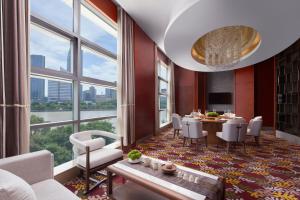 a dining room with a table and chairs and large windows at Ningbo Marriott Hotel in Ningbo