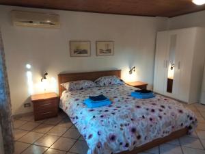 een slaapkamer met een groot bed met 2 nachtkastjes bij ZÍ MARIO Suite degli Ospiti - Roma Ostia Antica in Ostia Antica