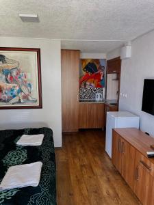 a small room with two beds and a television at Studio By the Lake in Ohrid