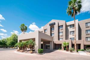 a building with palm trees in front of it at SpringHill Suites Scottsdale North in Scottsdale