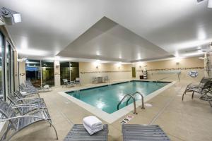 a pool in a hotel with chairs at TownePlace Suites by Marriott Providence North Kingstown in North Kingstown