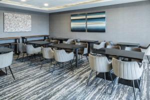 un comedor con mesas, sillas y una pared en TownePlace Suites by Marriott Providence North Kingstown en North Kingstown