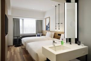 a hotel room with two beds and a sink at Fairfield by Marriott Osaka Namba in Osaka