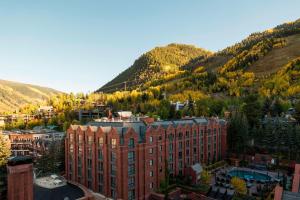 a large red brick building in front of a mountain at St. Regis Aspen Resort in Aspen