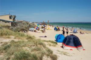 - un groupe de personnes sur une plage avec des tentes dans l'établissement Aspendale Beach Escape -Walk To Mordialloc, à Aspendale
