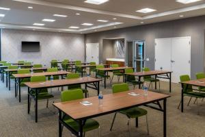 a conference room with tables and chairs and a screen at SpringHill Suites by Marriott Overland Park Leawood in Overland Park