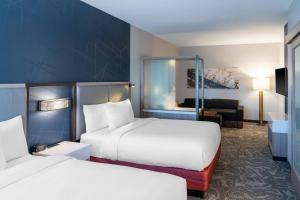 a hotel room with two beds and a living room at SpringHill Suites by Marriott Overland Park Leawood in Overland Park