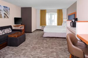 a hotel room with a bed and a couch at SpringHill Suites by Marriott Memphis East Galleria in Memphis