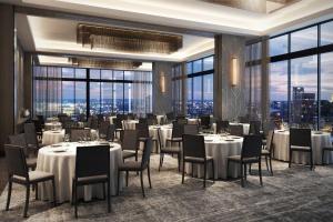 un ristorante con tavoli e sedie bianchi e ampie finestre di Element Miami Brickell a Miami