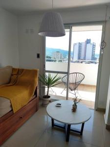 a living room with a bed and a table and a window at Hermosa energía in San Salvador de Jujuy