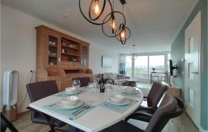 a dining room with a white table and chairs at Amazing Home In Stavenisse With Sauna in Stavenisse