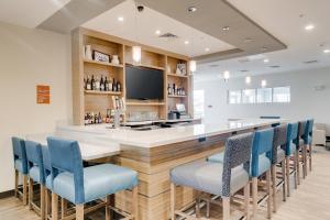 a bar with blue chairs and a television at TownePlace Suites by Marriott Kansas City Liberty in Liberty