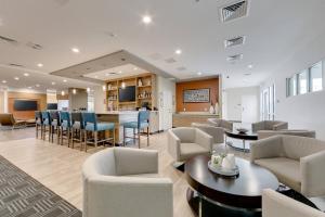 a living room with chairs and a dining room at TownePlace Suites by Marriott Kansas City Liberty in Liberty