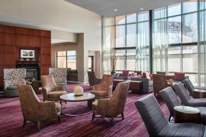 Courtyard by Marriott Newark Elizabeth في إليزابيث: لوبي فيه كنب وكراسي وموقد