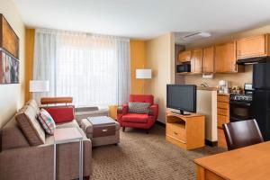 TownePlace Suites Phoenix North في فينكس: غرفة معيشة مع أريكة وتلفزيون