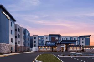 Residence Inn by Marriott Rehoboth Beach في شاطئ ريهوبوث: تقديم الشكل الخارجي للفندق مع وجود مواقف للسيارات