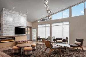 a lobby with tables and chairs and a fireplace at Residence Inn by Marriott Rehoboth Beach in Rehoboth Beach