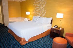 a hotel room with a bed and a bath tub at Fairfield Inn & Suites Butler in Butler