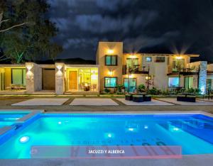 a house with a swimming pool at night at Bottega Hotel Boutique in Valle de Guadalupe
