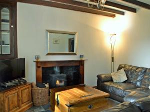 a living room with a couch and a fireplace at Holly Cottage in Ystalyfera