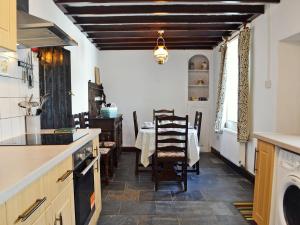 a kitchen with a table and a dining room at Holly Cottage in Ystalyfera