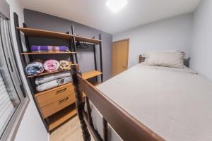 Dormitorio pequeño con cama y armario en Fenavinho-Bento Gonçalves en Bento Gonçalves