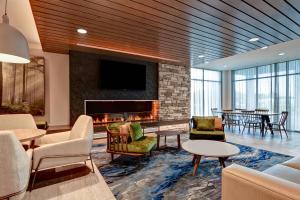 a lobby with a fireplace and tables and chairs at Fairfield Inn & Suites by Marriott Selinsgrove in Selinsgrove