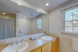 a bathroom with two sinks and a large mirror at Cotuit Mannor in Cotuit +39 photos