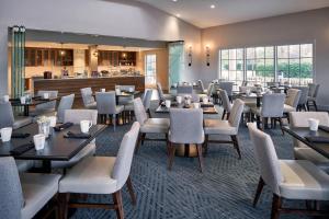 a restaurant with tables and chairs and a bar at Delta Hotels by Marriott Norfolk Airport in Norfolk