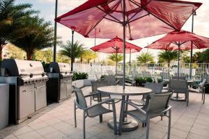 eine Terrasse mit einem Tisch, Stühlen und Sonnenschirmen in der Unterkunft TownePlace Suites by Marriott Miami Homestead in Homestead