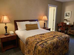 een hotelkamer met een bed en twee lampen bij Kingston Hotel in Vancouver