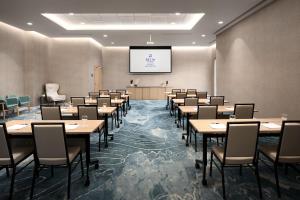 a conference room with tables and chairs and a screen at Delta Hotels by Marriott Vancouver Delta in Delta