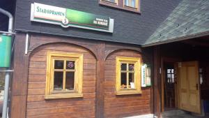 a wooden building with windows and a sign on it at Country club Konírna in Šluknov