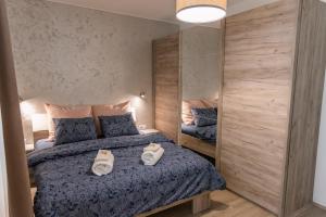 a bedroom with a bed with two white shoes on it at Apartman Mila23 in Rospi Ćuprija