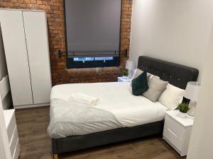 a bedroom with a bed with a brick wall at Luxury one bed apartment in Manchester city center in Manchester