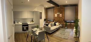 a living room with a couch and a kitchen at Luxury one bed apartment in Manchester city center in Manchester