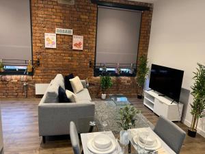 a living room with a couch and a tv at Luxury one bed apartment in Manchester city center in Manchester