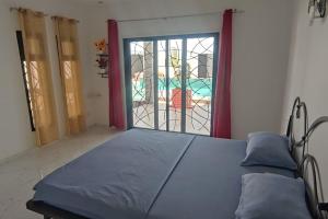 a bedroom with a bed and a window with a view at Paradis in Ngaparou +31 photos