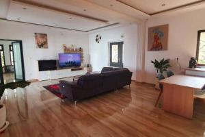a living room with a couch and a flat screen tv at Paradis in Ngaparou