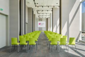 an empty room with green chairs and a screen at Aloft Montevideo Hotel- Marriott International in Montevideo